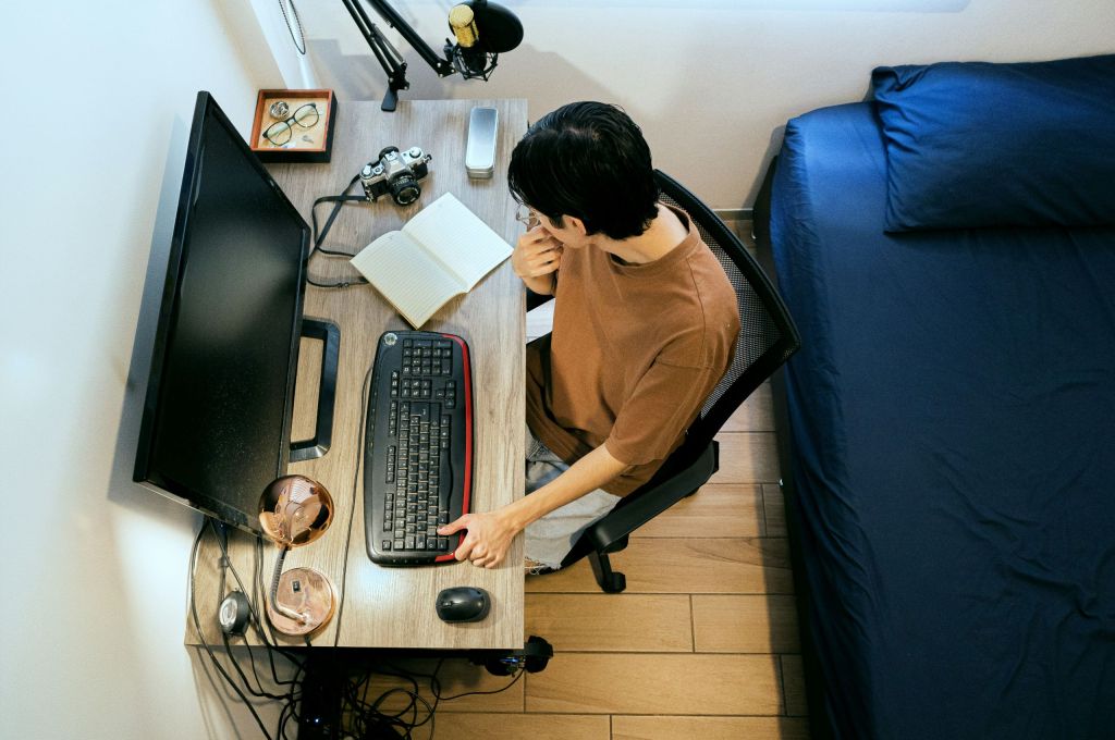 Person sitting at a desk looking at a laptop while planning how to host a virtual fundraiser.