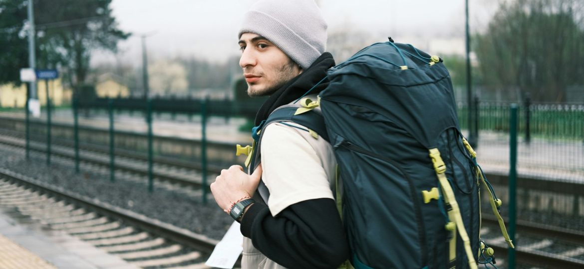 A man with a backpack traveling on a budget