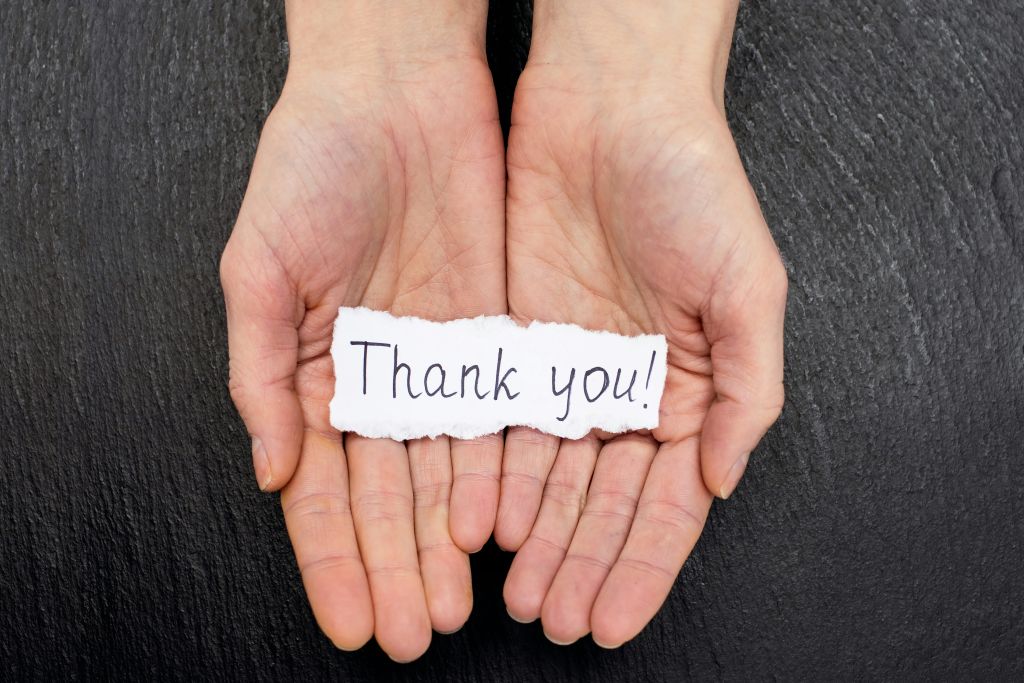 Hands holding “Thank you” paper sign