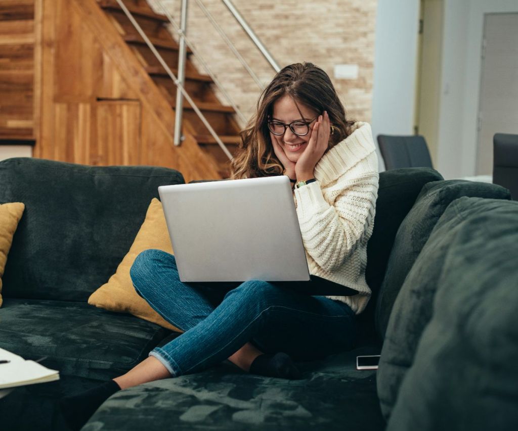 Woman smiling while working on a laptop at home