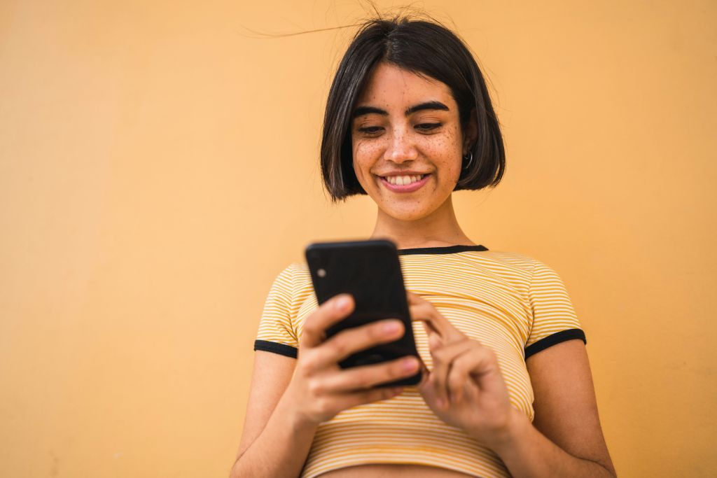 Woman using phone to share her FundMyTravel campaign