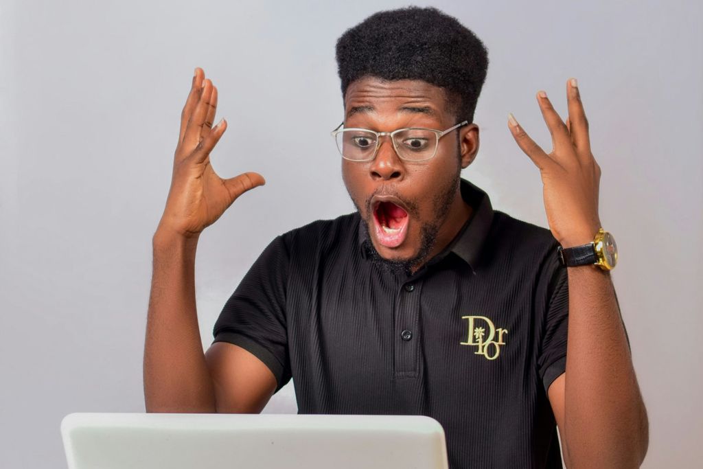 Man excited while checking FundMyTravel campaign updates