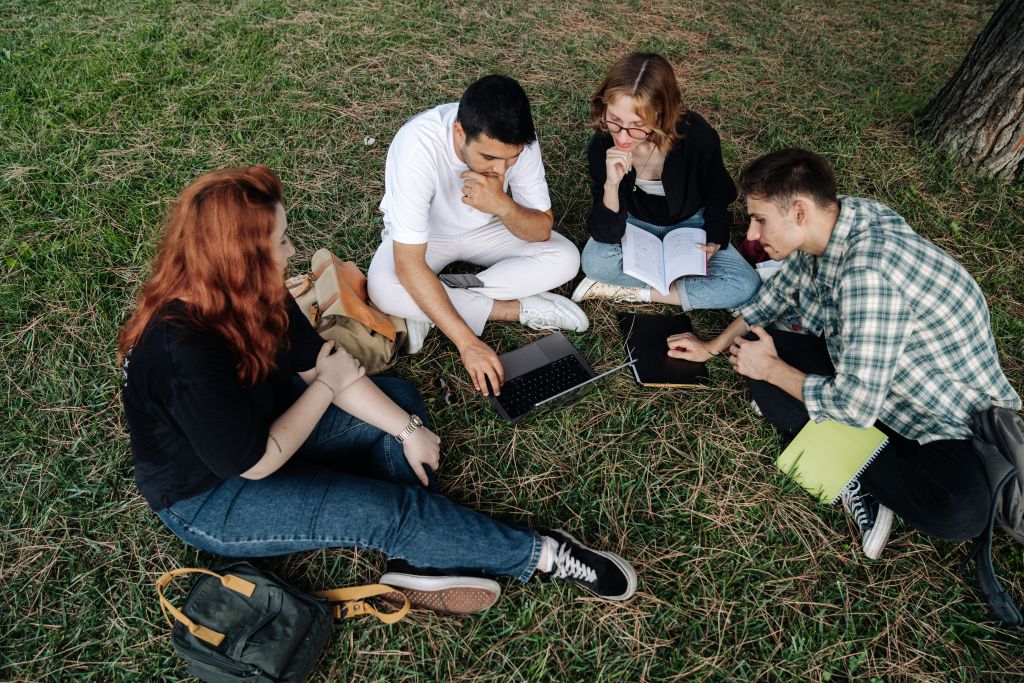 Friends sitting on the ground talking about  Volunteer Abroad