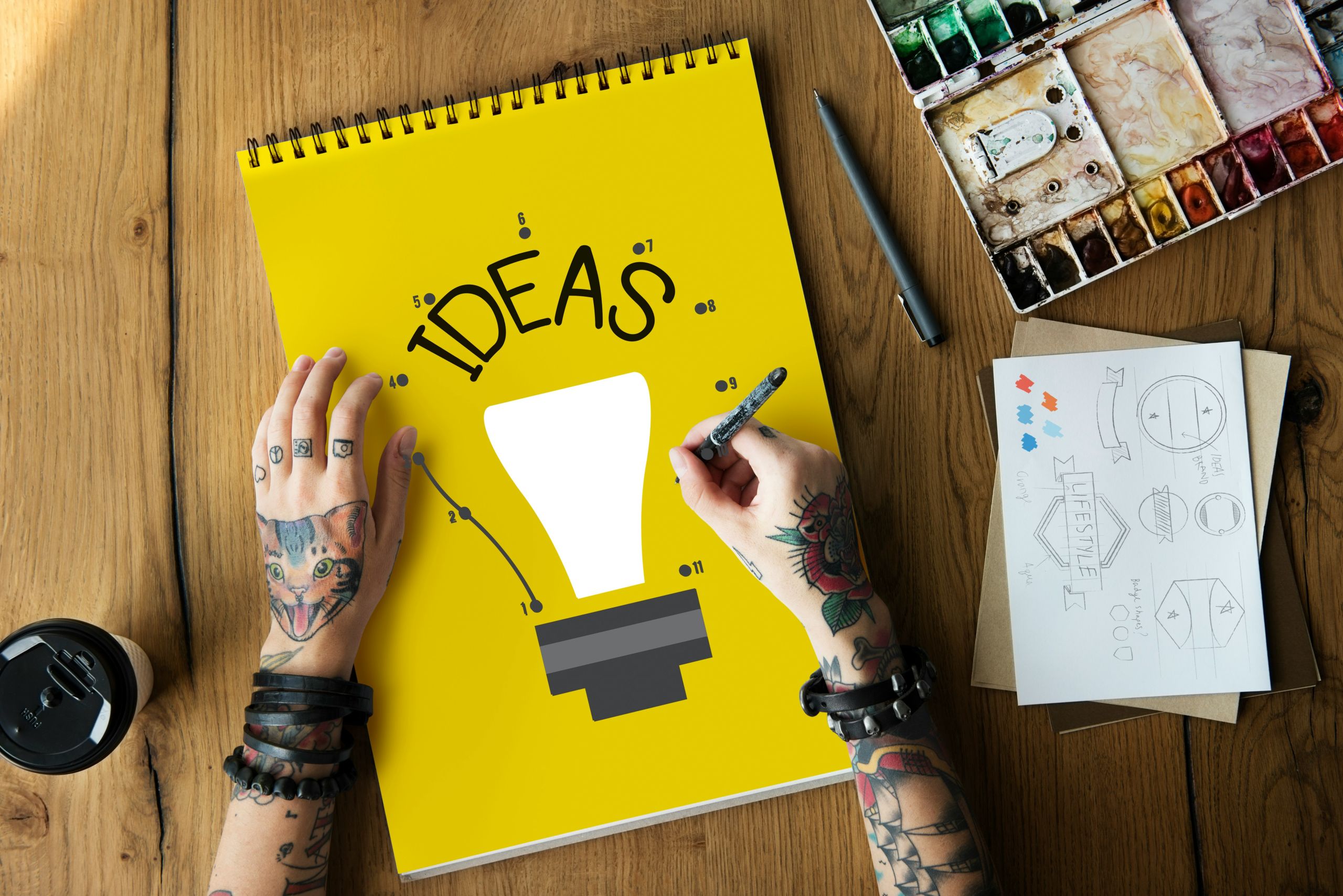 A person's hand writing fundraising ideas