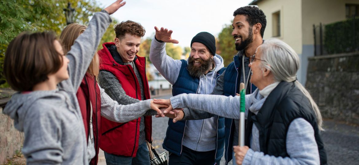 A group of smiling people putting their hands together in a huddle