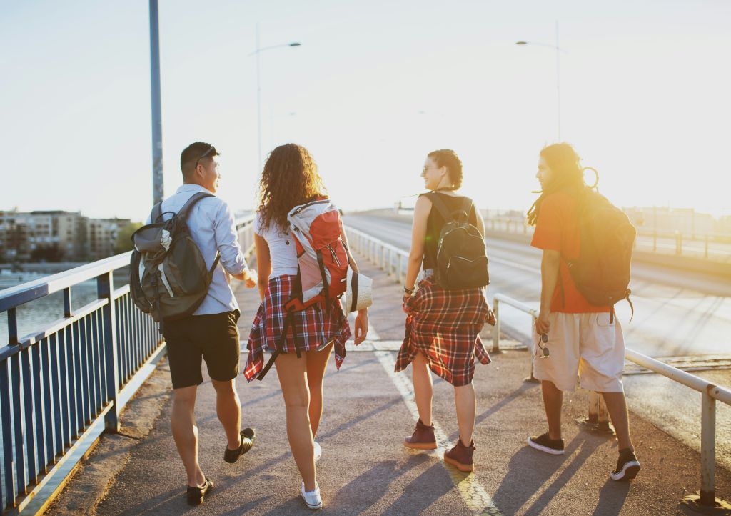 Four friends walking on bridge.